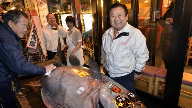 Sushi-Zanmai owner Kiyoshi Kimura poses next to the 269 kilogram bluefin tuna he purchased on the first trading day of the new year at Tokyo's Tsukiji fish market.