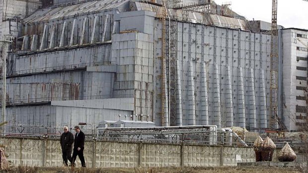 Workers walk in front of the fourth reactor at the Chernobyl.