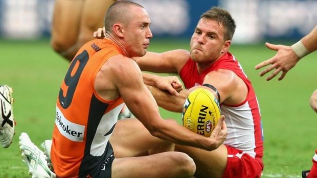 Tom Scully of the Giants and Ben McGlynn of the Swans keep their eye on the ball.