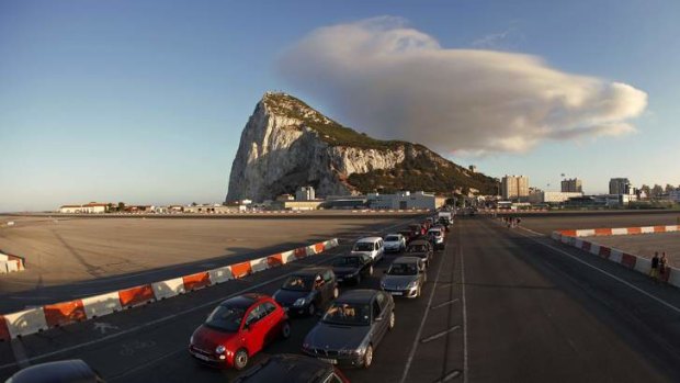 Drivers wait in line along the road of the Gibraltar International airport to enter to Spain at its border with the British territory of Gibraltar.