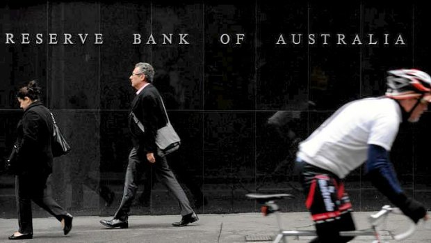 Pedestrians and a cyclist go past the Reserve Bank of Australia (RBA) headquarters in the central business district of Sydney, Australia.