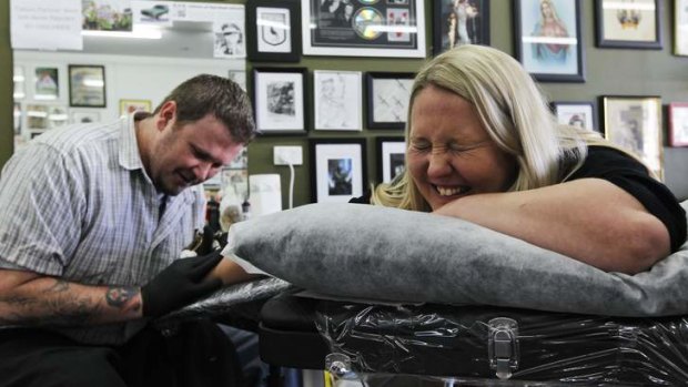 Rebecca Fletcher gets a tattoo on her wrist - her late father's signature - by artist Dave Lynas at a Thornliegh tattoo parlour.