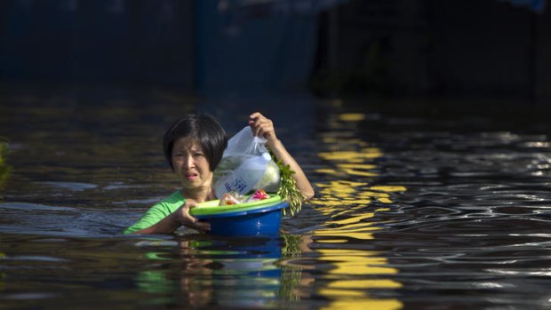 A Thai woman makes her way through floodwaters on the outskirts of Bangkok last month.