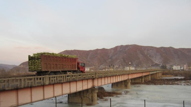 A loaded truck crossingTumen River toward North Korea. You can just about make out Kim Il-Sung's portrait on the other side.