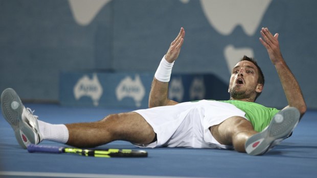Flat out: Viktor Troicki lies down on the court as he celebrates winning the men's final.