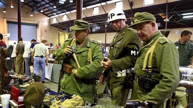 Pat Ryan in an Africa Korp uniform, David Smith in a American MP uniform and Trevor Atchison in an Africa Korp uniform inspect the wares on show at the Big Show Antique and Military Fair at the RNA Showgrounds.