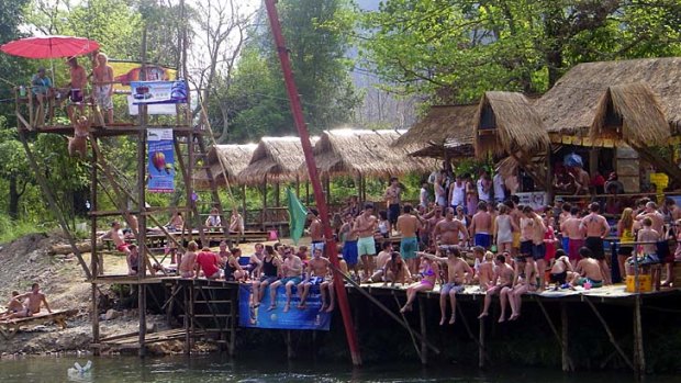 The banks of the river in Vang Vieng are lined with makeshift wooden bars.