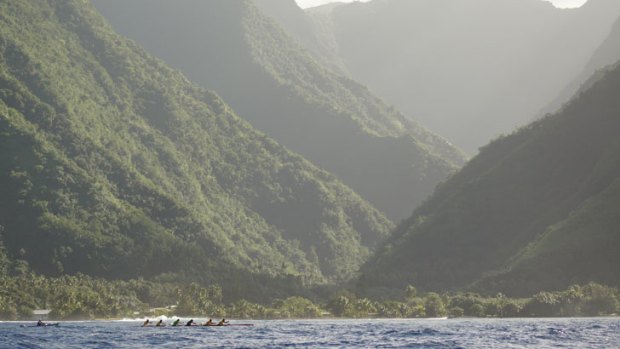 The canoes are dwarfed by Tahiti's spectacular landscape.