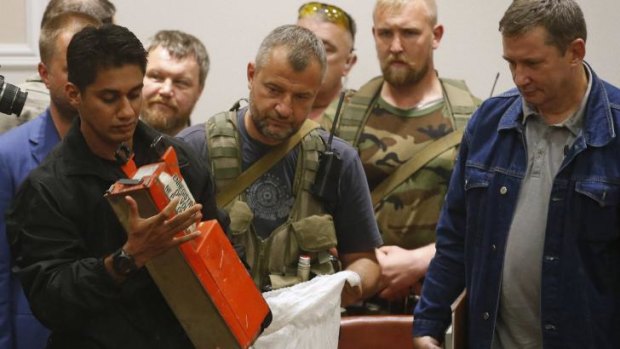 A Malaysian expert examines the MH17 black box after receiving it from pro-Russian rebels.