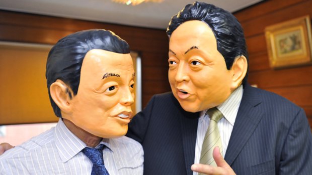 Employees of Ogawa Rubber, Japan's top rubber mask maker, wear rubber masks of Taro Aso and Yukio Hatoyama.