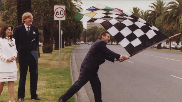 Pic published and filed: 12-6-94 Photo by John Lamb. Victorian premier, Jeff Kennett waves chequered racing flag at Albert Park while Ron Walker and Judith Griggs look on. The three had gathered to open new offices for Melbourne Major Events and Melbourne Grand Prix Promotions.