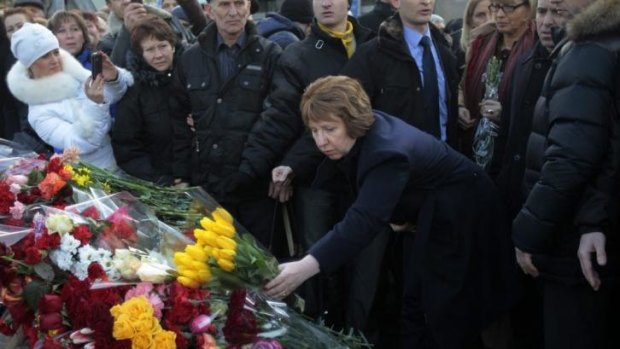 White knight?: EU foreign policy chief Catherine Ashton places flowers at a memorial for people killed in clashes with the police in Kiev.