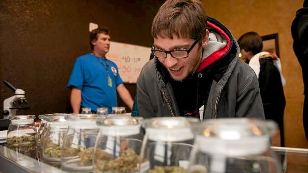 Man selects marijuana strains to purchase at the 3-D Denver Discrete Dispensary in Denver, Colorado.