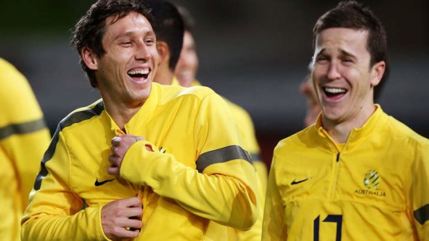 Grinners but not winners yet: Mark Milligan and Matt McKay share a joke at Socceroos training on Thursday night.