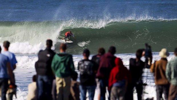 Fans watch as Kelly Slater during the Rip Curl Pro Search surfing competition at Ocean Beach in San Francisco.