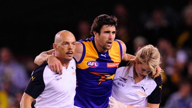 West Coast worries: Josh Kennedy is helped from the field after injuring his ankle.