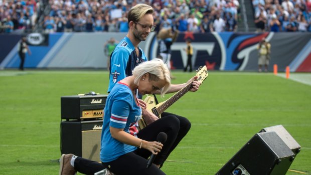 Meghan Linsey kneels after singing the national anthem before the start of the Tennessee Titans and Seattle Seahawks football game at Nissan Stadium in Nashville on Sunday.