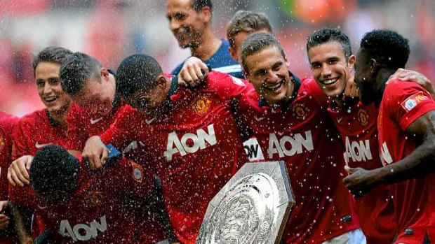 (From right) Danny Welbeck, Robin van Persie and Nemanja Vidic of Manchester United celebrate with the trophy.