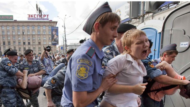Riot police and city police officers detain anti-Kremlin activists during a protest in Moscow.