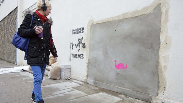 A woman walks past the site after Banksy's mural 'vanished'.
