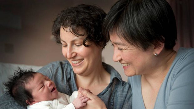 Early arrival: Senator Penny Wong holds hands with new daughter Alexandra in Adelaide as partner Sophie Allouache looks on.