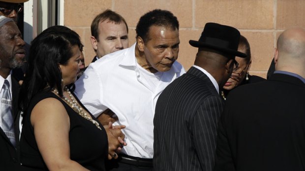 Unsteady on his feet, Muhammad Ali is helped into church for the funeral of fellow boxer Joe Frazier.