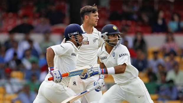 India's captain M.S. Dhoni and Virat Kohli take a quick single as New Zealand's James Franklin watches.