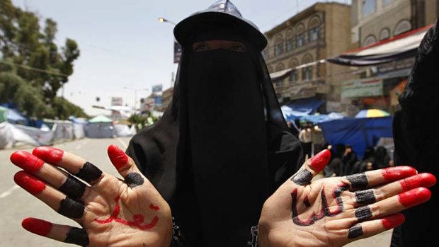 A Yemeni anti-government protester shows her hands bearing the writing in Arabic "We are all Taez (Taiz)".