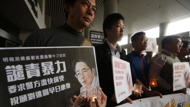 Pro-democracy protesters hold a picture of former Ming Pao chief editor Kevin Lau during a demonstration outside a hospital in Hong Kong.