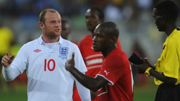 Fired up ... Wayne Rooney is booked by Jeff Selogilwe