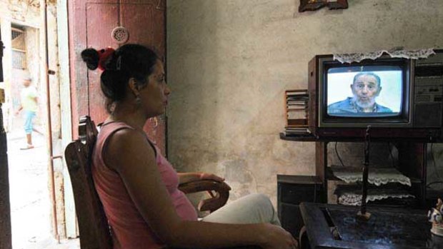 A woman watches former Cuban president Fidel Castro on TV in Havana.