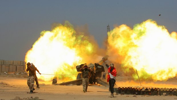 Iraqi security forces and allied Popular Mobilization forces fire artillery during fight against Islamic State militants in Fallujah.