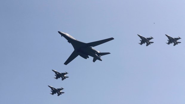 US B-1 bomber, centre, flies over Osan Air Base accompanied by jet fighters.