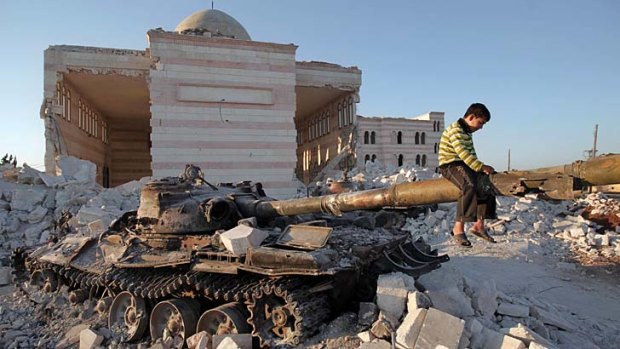 No longer a conflict but a war &#8230; a boy plays on a wrecked Syrian army tank north of Aleppo.