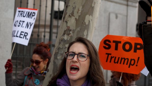 In Madrid, a women joins thousands at an anti-Trump march.