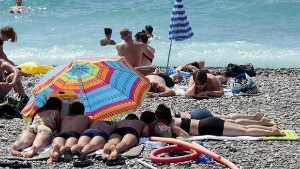 Warm summers: Tourists enjoy the sun on the beach in Nice, southeastern France.
