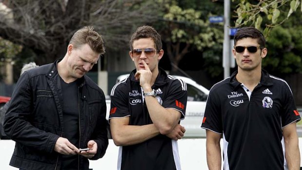 Collingwood assistant coach Nathan Buckley talks to Luke Ball and Sharrod Wellingham after the players were presented to the Magpies supporters yesterday.