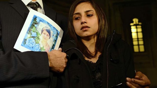 Distraught ... Lisha Barboza, daughter of dead nurse Jacintha Saldanha, leaves Britain's Houses of Parliament with father, Ben, carrying a photo of her mother.