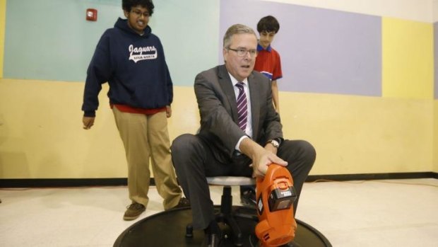 Might have a go: Former Florida governor Jeb Bush steers a leaf blower-powered hovercraft built by students in Arkansas.