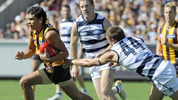 The Cats' Corey Enright tries to stop the Hawks' Cyril Rioli during the match at the MCG, which Geelong won by nine points.