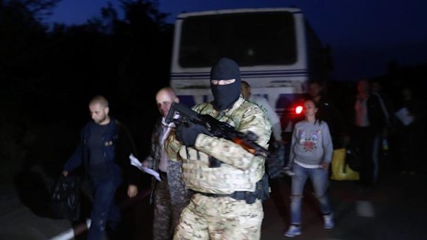 Political swap: A Ukrainian soldier guards pro-Russian prisoners-of-war during a prisoner exchange near the town of Donetsk.