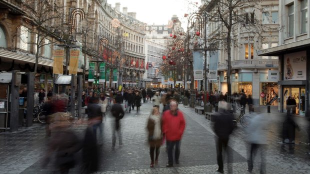 People walk down the main shopping street called the Meir in Antwerp, Belgium. 