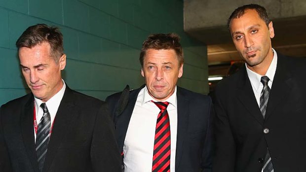 Mark Thompson is escorted by security as he leaves AFL House on Tuesday.