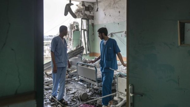 Medical workers assess the damage of a hospital hit during shelling in Deir al-Balah.