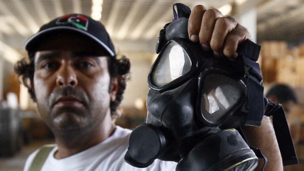 Protection ... rebel Mohamed Biskri with a gas mask from the former Gaddafi military base in Abu Shweicha, a town 120 kilometres west of Tripoli.