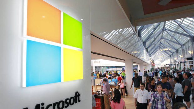 A new Microsoft logo, left, is seen on an exterior wall of a new Microsoft store inside the Prudential Center mall, in Boston.