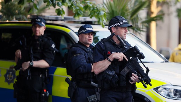 Armed police watch over a vigil in Albert Square, Manchester, on Tuesday.