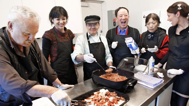 Jim (left) prepares his moussaka with other senior residents while dietitians Isabella de Castella (second from left) and Kara Beath (right) offer advice.