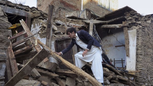 A man checks a house damaged in Monday's  earthquake in Mingora, the main town in Pakistan's Swat valley.