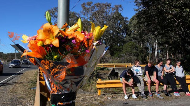Shocked: Young friends gather at the crash site of Philip Vassallo on Andrews Road in Penrith.